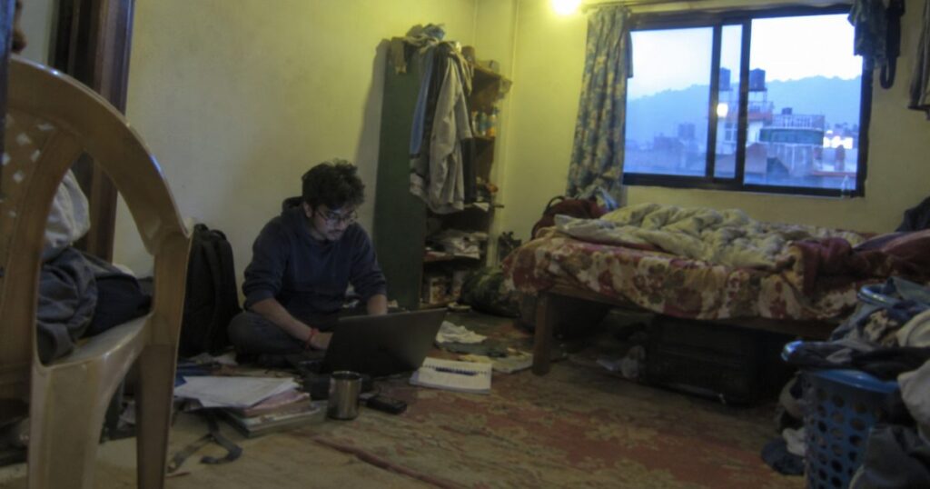 Nepali student planning to study abroad on a laptop in a room in Kathmandu